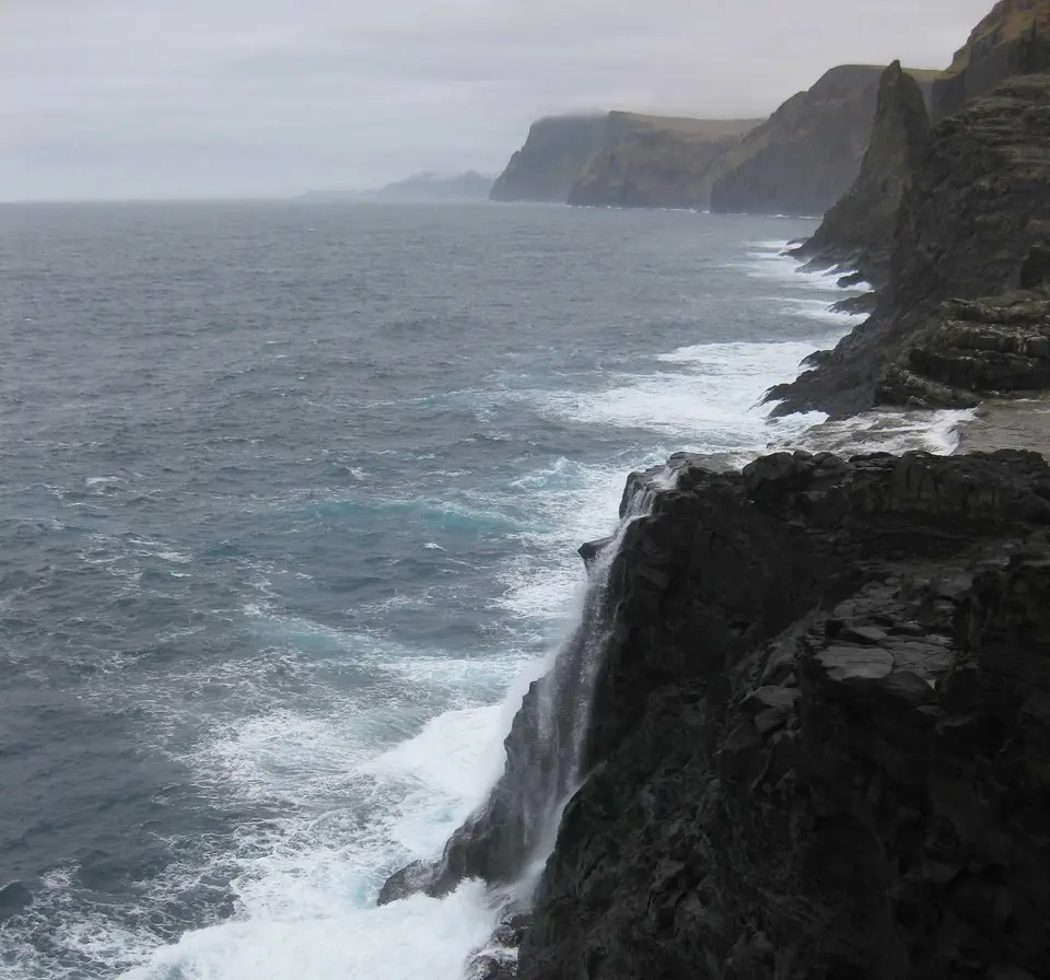 Der Wasserfall Bøsdalafossur fließt vom See ins Meer