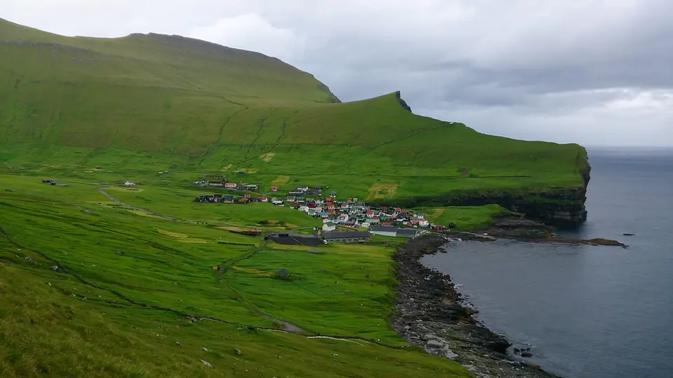Die Küste bei Gjógv mit grünem Hang