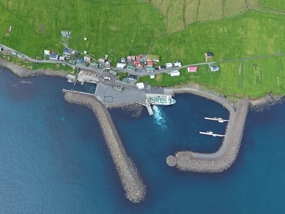 Luftbild von Dorf und Hafen auf Hestur