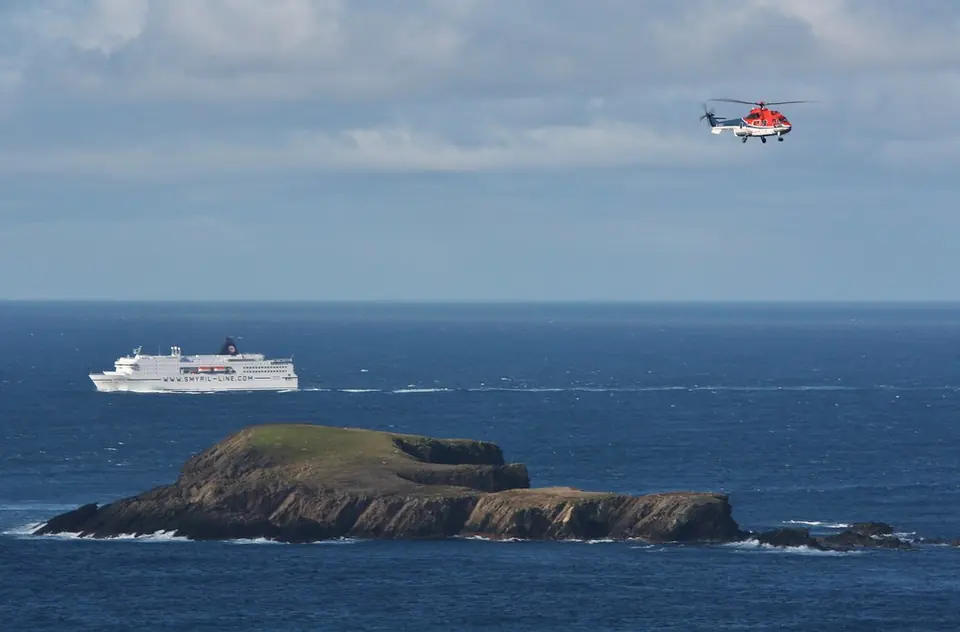 Smyril Lines Schiff Norröna auf See mit einem Hubschrauber darüber