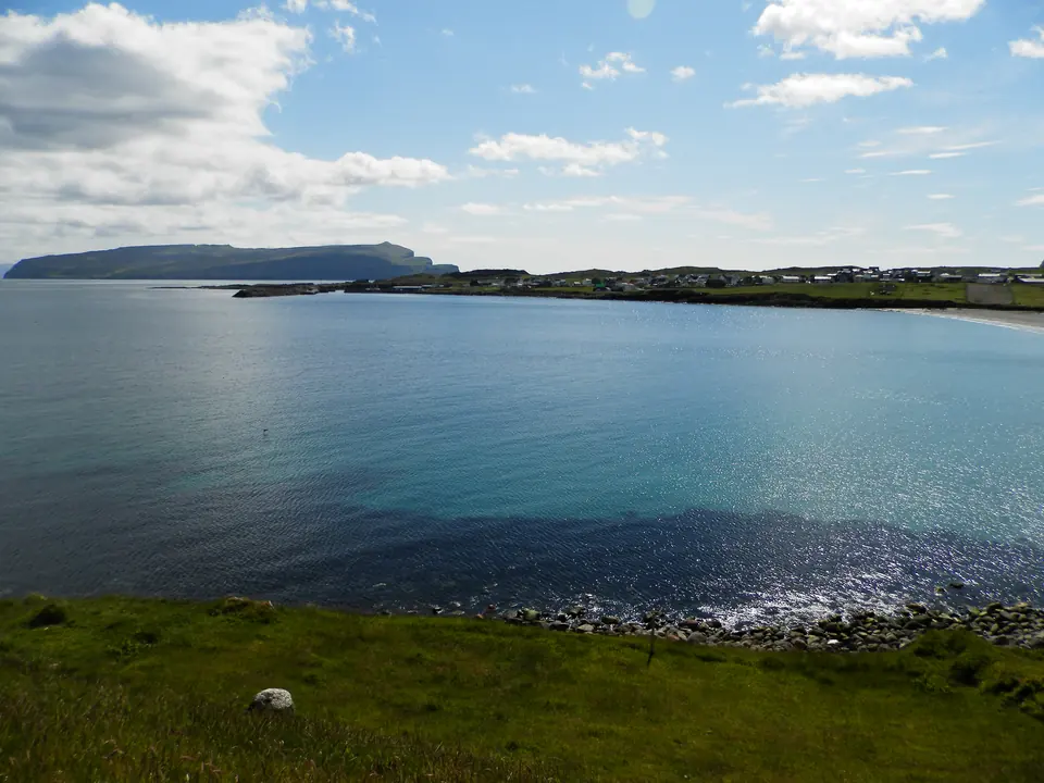 Sandur am Meer, im Hintergrund die Insel Skúvoy