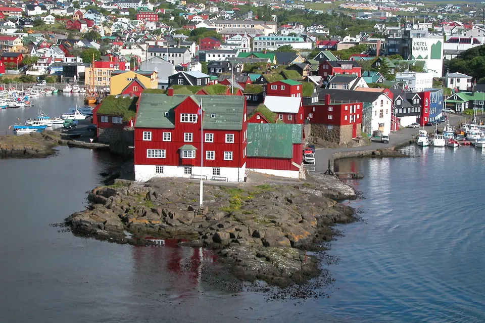 Udden Tinganes i Tórshavn sedd ovanifrån med röda hus och hamnarna